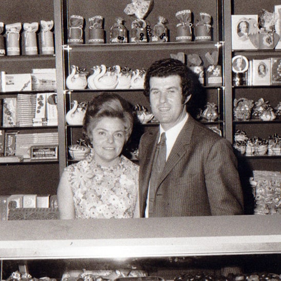Schwarz-weiß Bild mit Bruno und Gertrud Baumgartner hinter der Theke der damaligen Konditorei Baumgartner